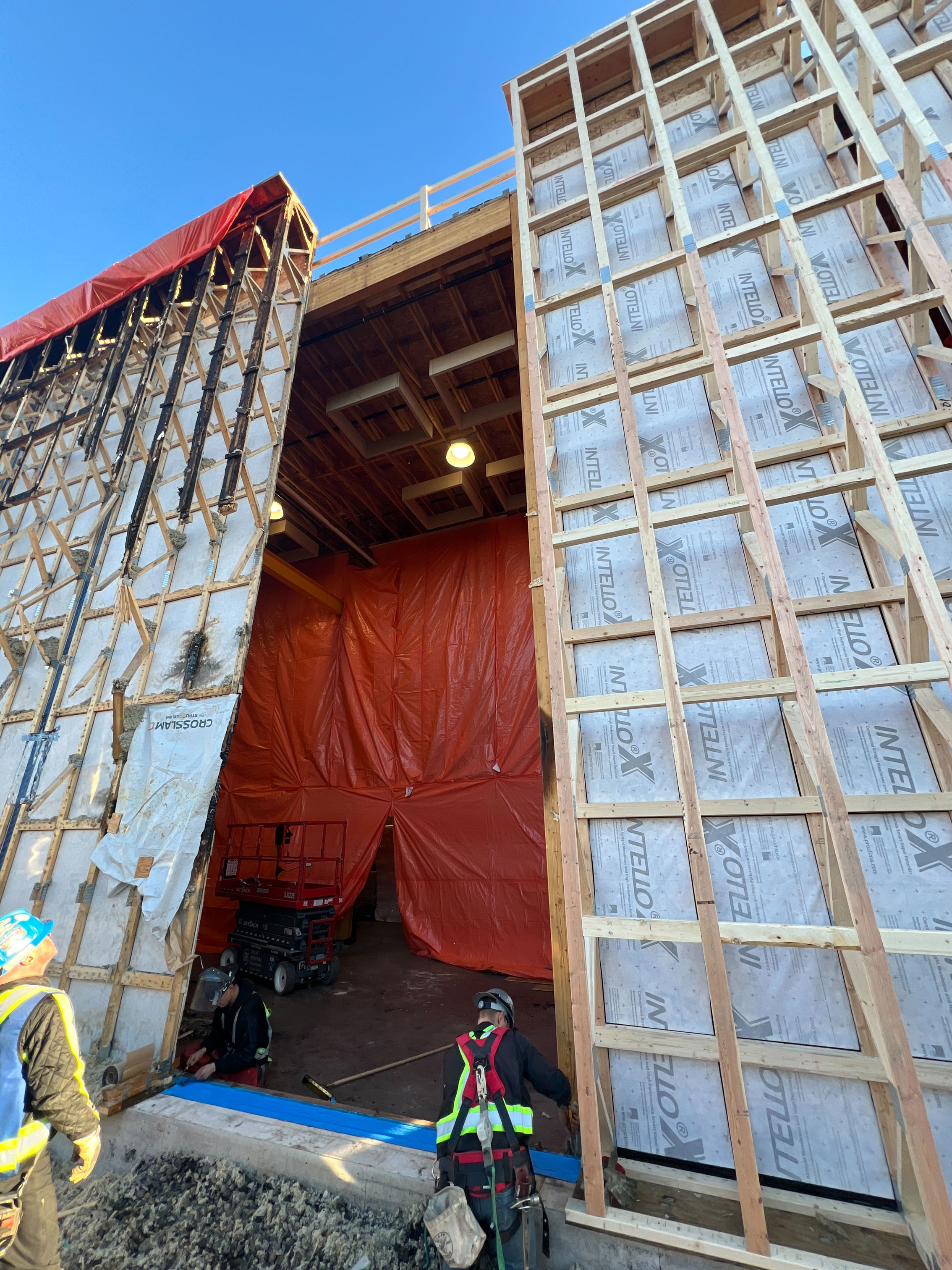 The damaged wall on the left, new panel on the right, and preparation for bringing in another panel to bridge the gap.