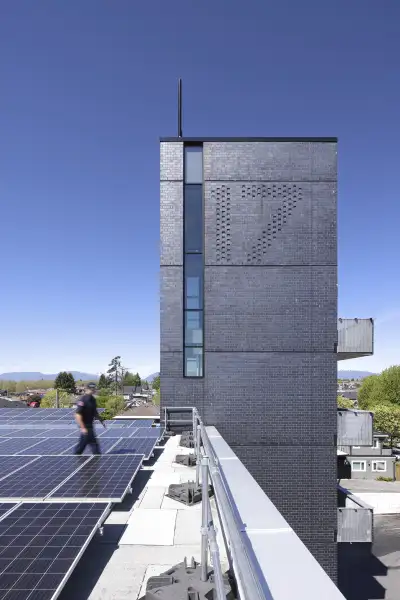 Walking among the PV array on the roof with the hose tower in the background.
